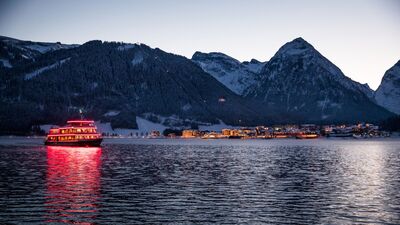 The MS Achensee cruising over Lake Achensee on a winter evening.