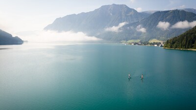 Explore Lake Achensee at a leisurely pace as you stand on a large surfboard and use a paddle to propel yourself through the water.