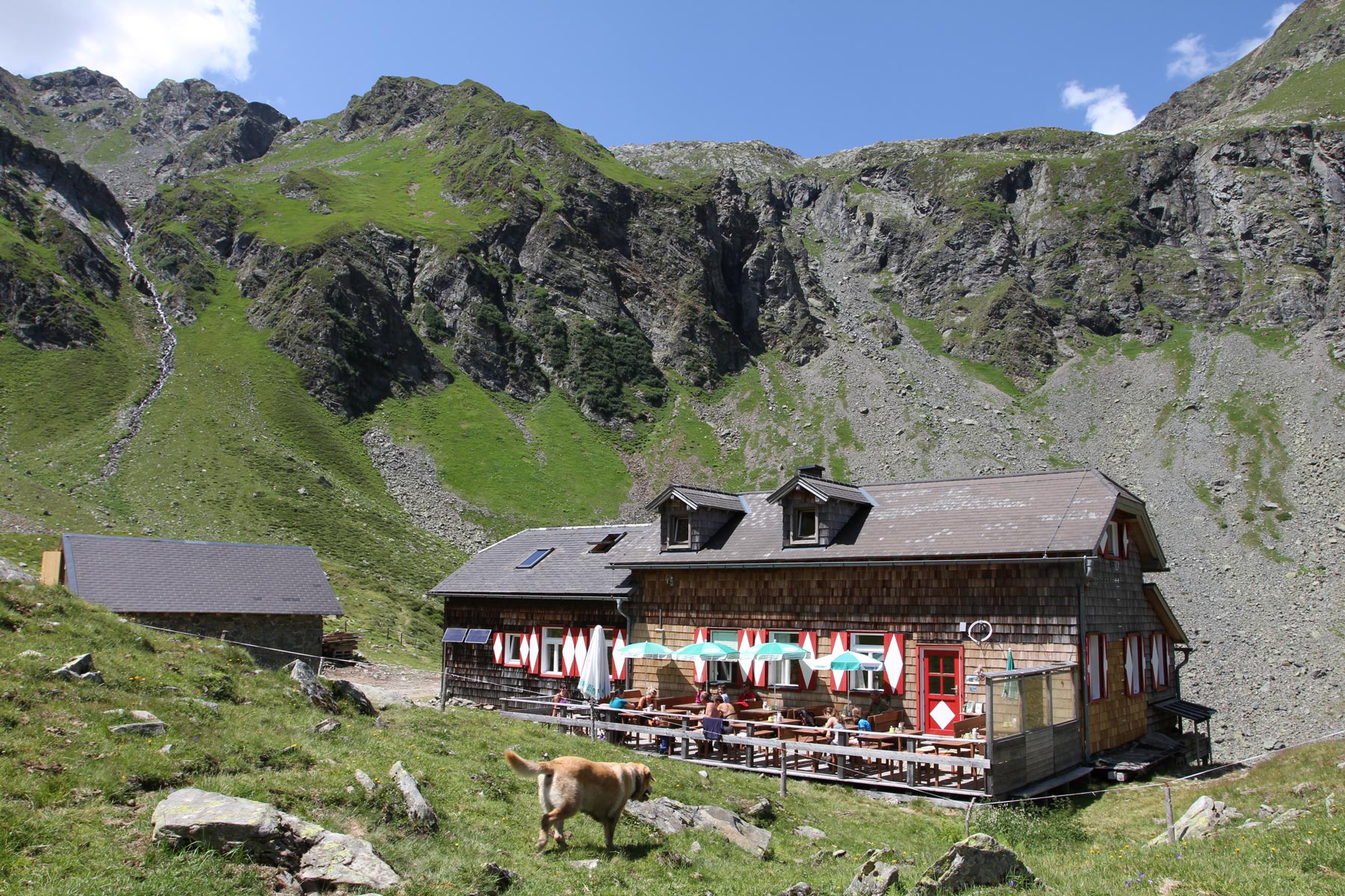 Die Keinprechthütte ist eine alpine Schutzhütte mit Außenterrasse. Sie liegt in einem Talkessel umgeben von steilen, grasbewachsenen Felshängen.