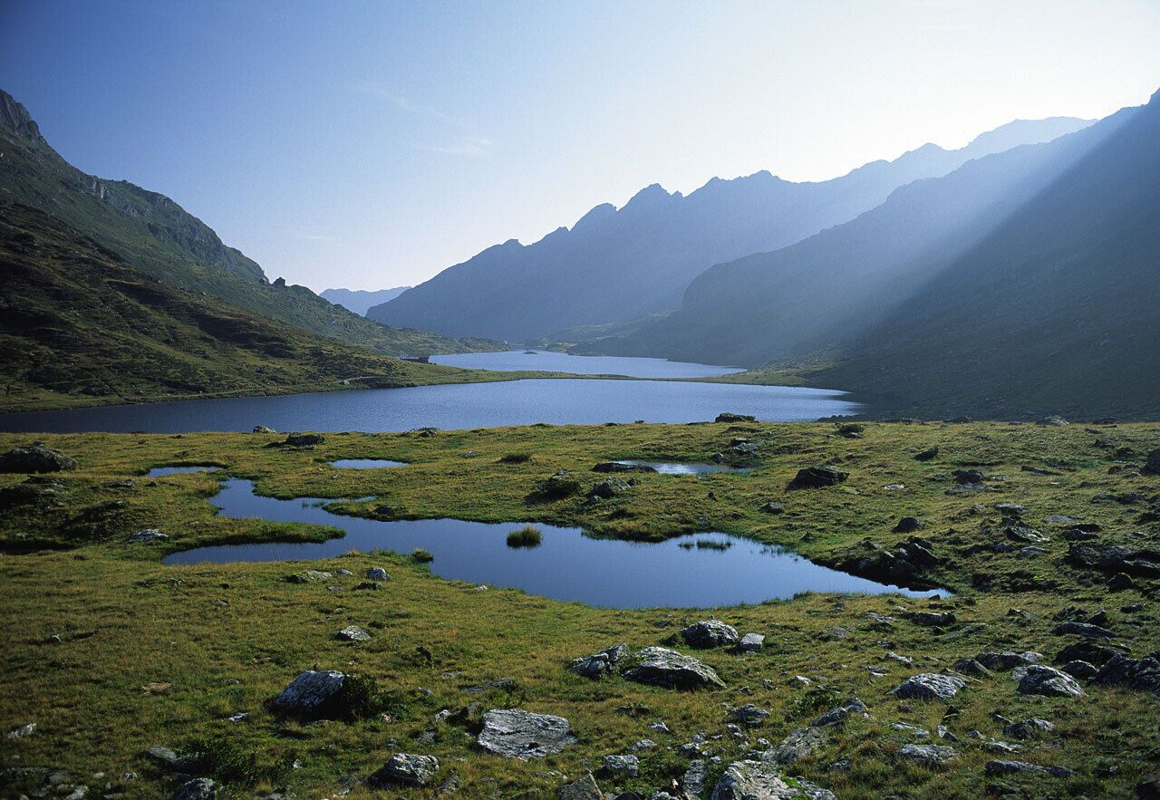 Die Aufnahme zeigt die Giglachseen in den Schladminger Tauern. Die Seen liegen eingebettet in eine alpine Graslandschaft umgeben von markanten Berggipfeln.